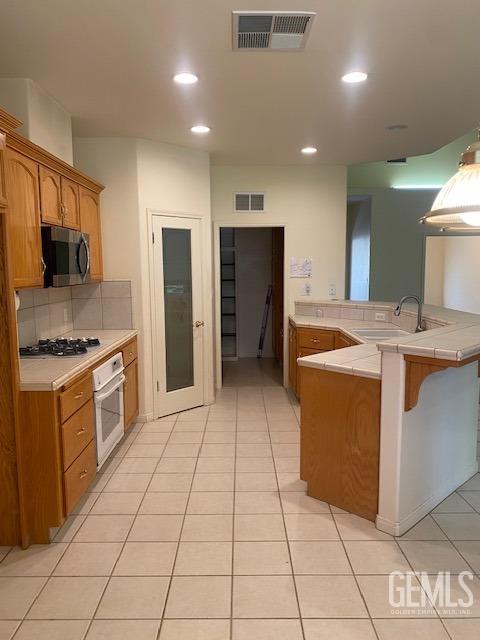 Undisclosed Address Bakersfield, CA 93312 - Photo 6 of 19 a kitchen with a stove a sink and a refrigerator