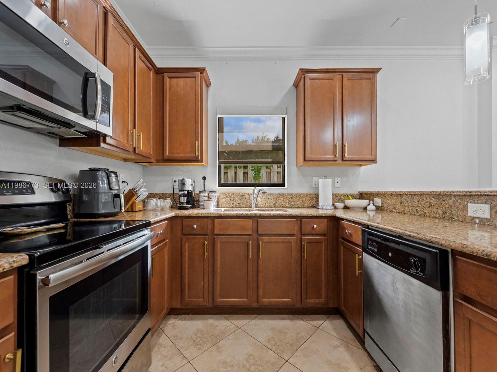 15404 Southwest 175th Street Miami, FL 33187 - Photo 11 of 38 a kitchen with stainless steel appliances granite countertop a sink stove and microwave