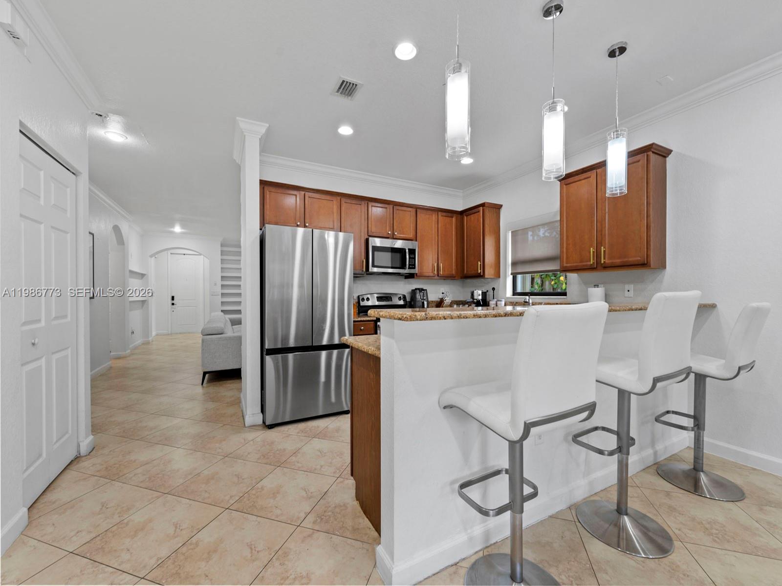 15404 Southwest 175th Street Miami, FL 33187 - Photo 12 of 38 a kitchen with stainless steel appliances granite countertop a refrigerator and a stove top oven