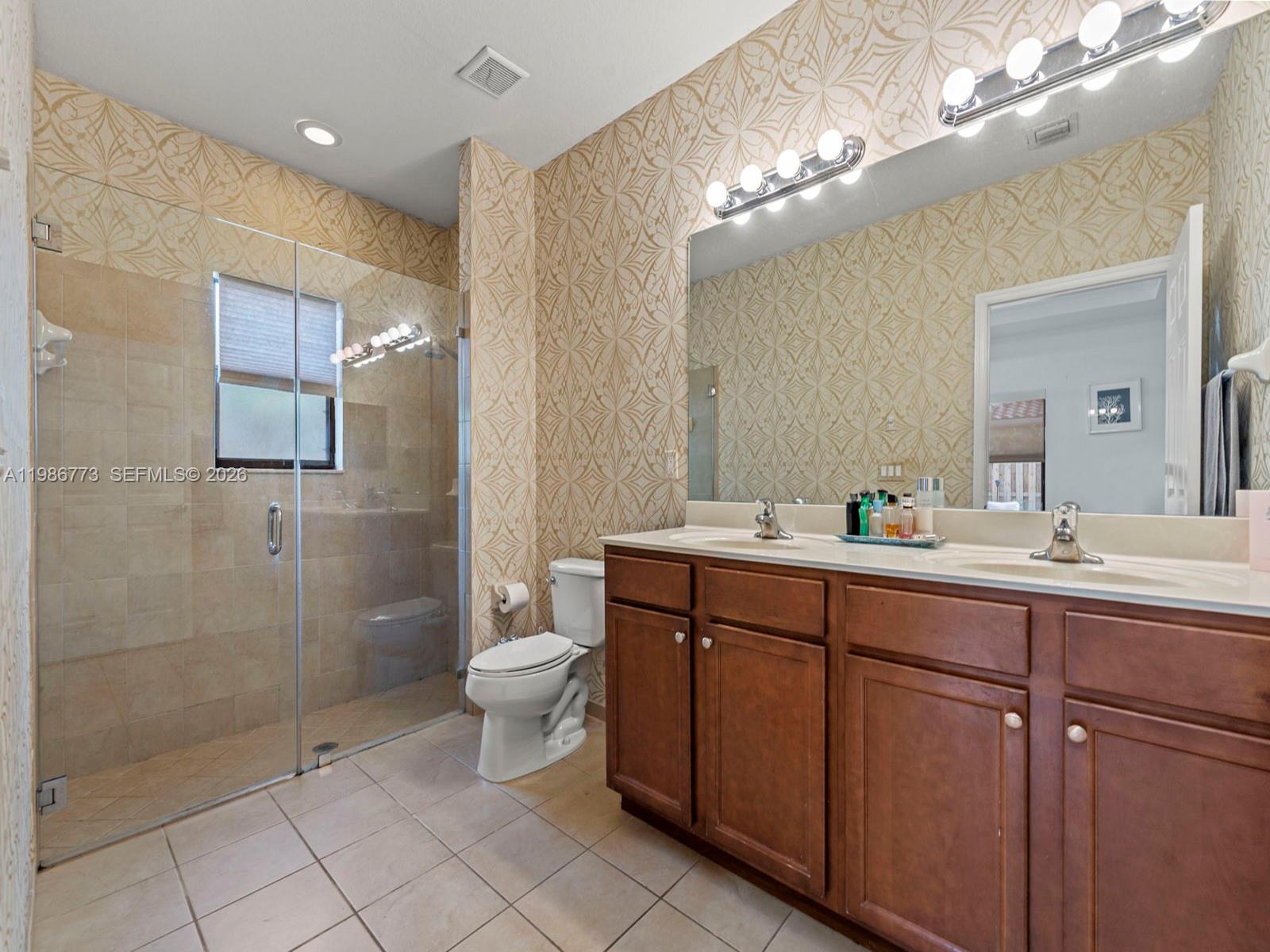 15404 Southwest 175th Street Miami, FL 33187 - Photo 19 of 38 a bathroom with a double vanity sink mirror and toilet