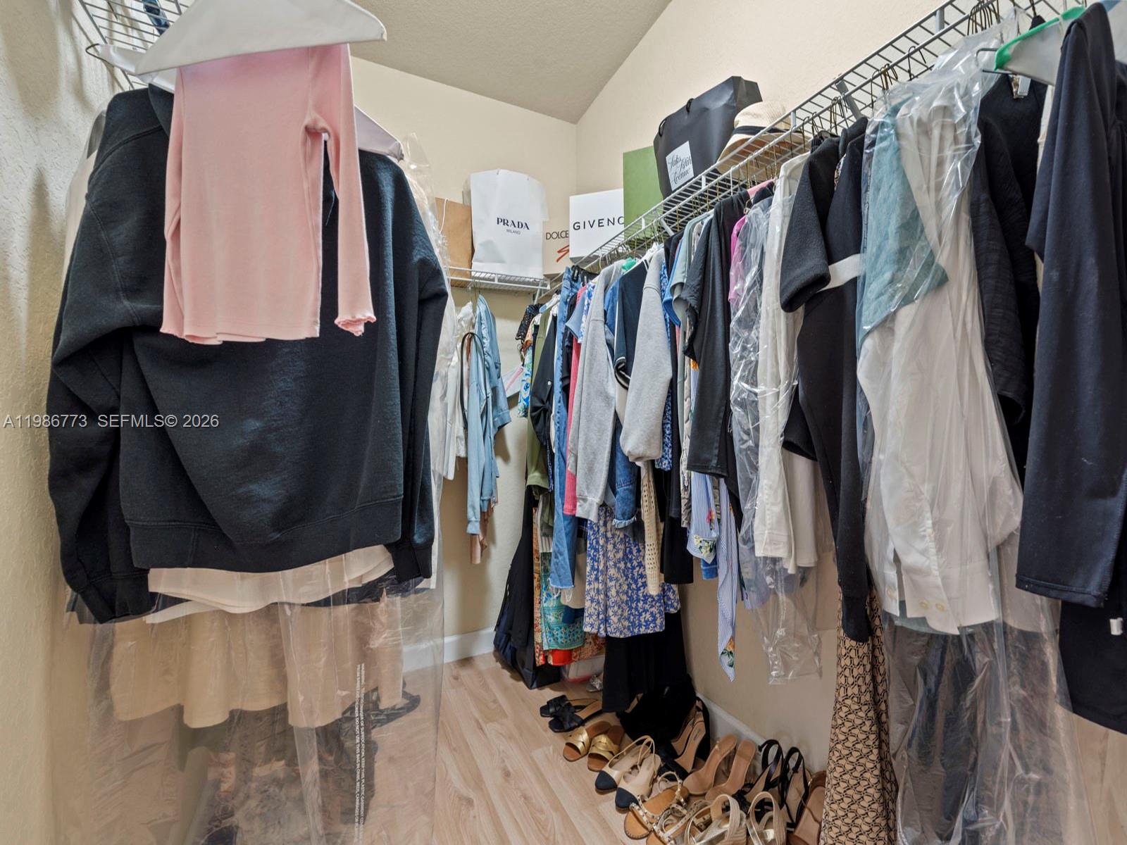 15404 Southwest 175th Street Miami, FL 33187 - Photo 20 of 38 a view of walk in closet with clothes and shoes