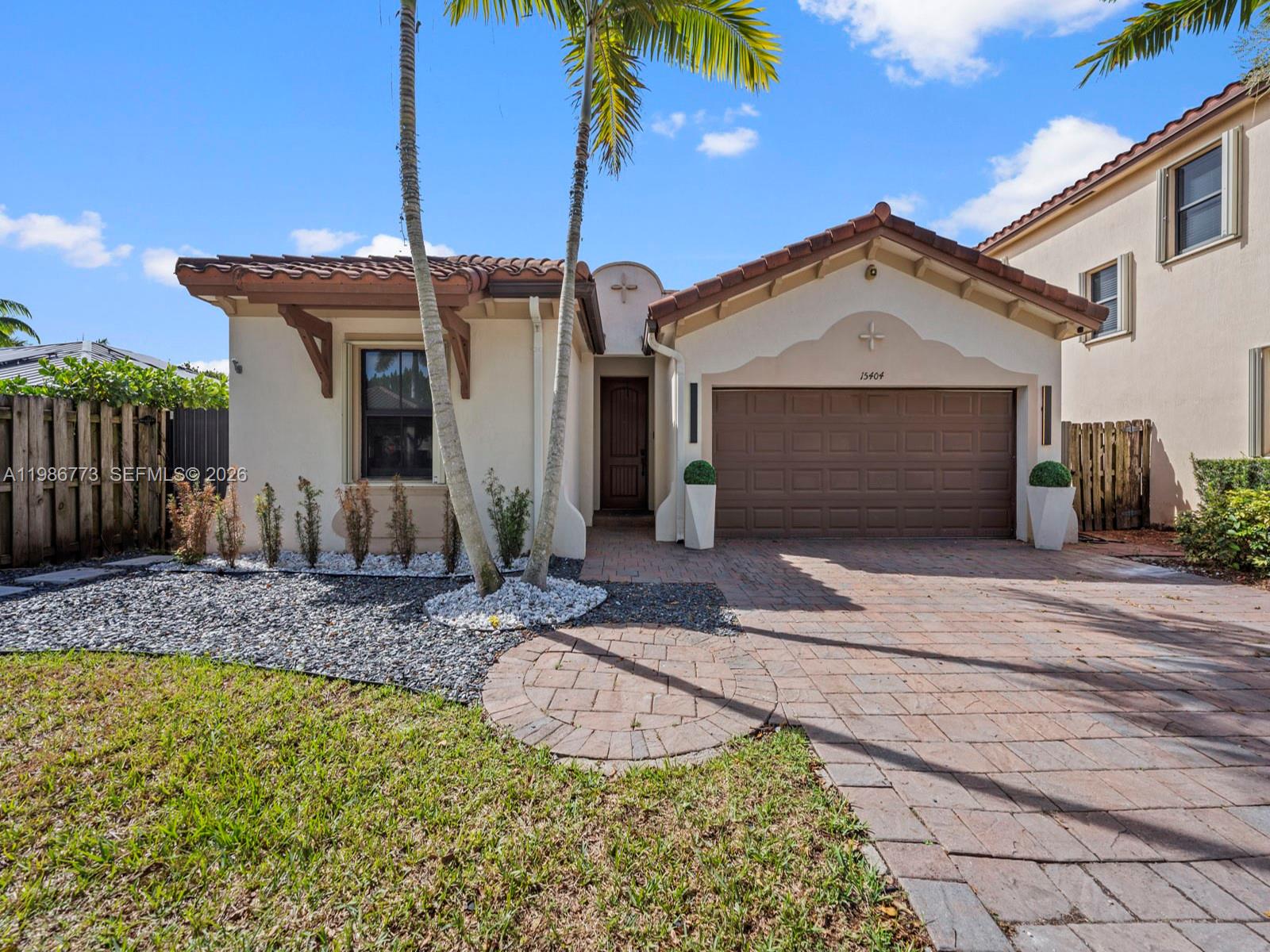15404 Southwest 175th Street Miami, FL 33187 - Photo 2 of 38 a front view of a house with garden