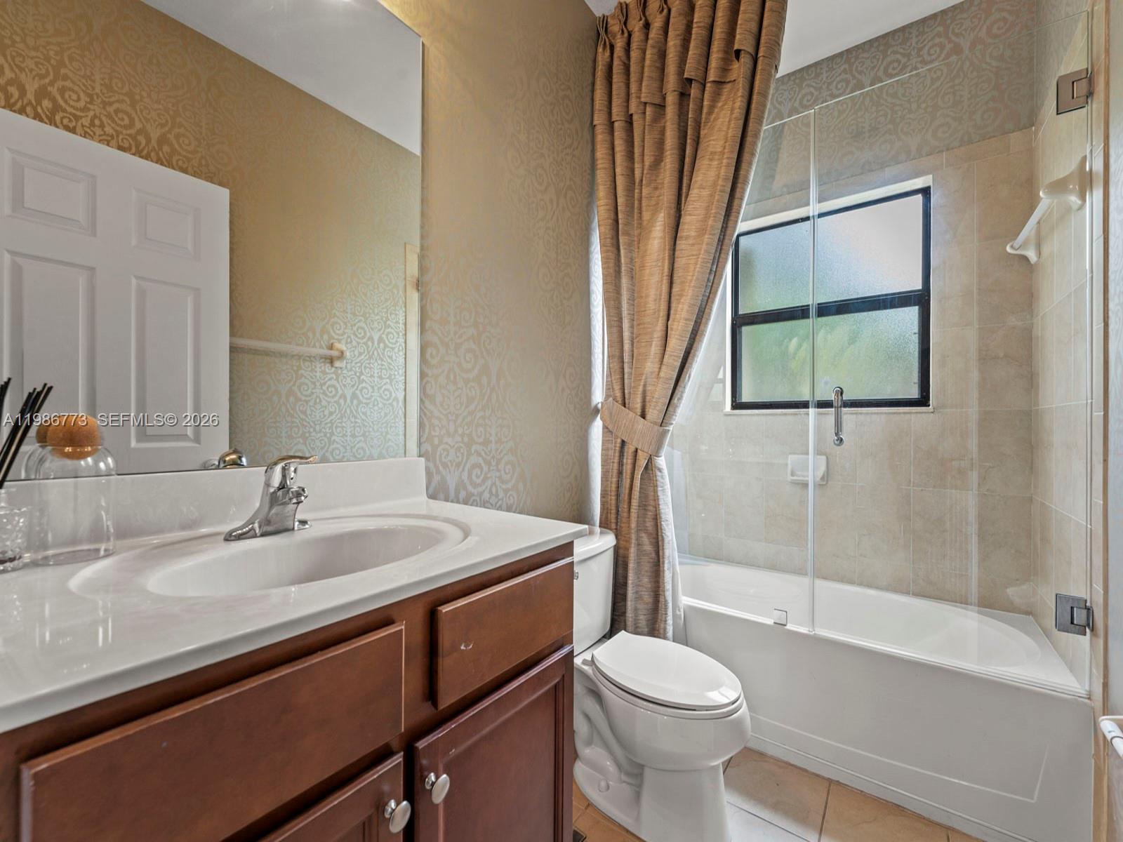 15404 Southwest 175th Street Miami, FL 33187 - Photo 23 of 38 a bathroom with a sink a toilet and a bathtub