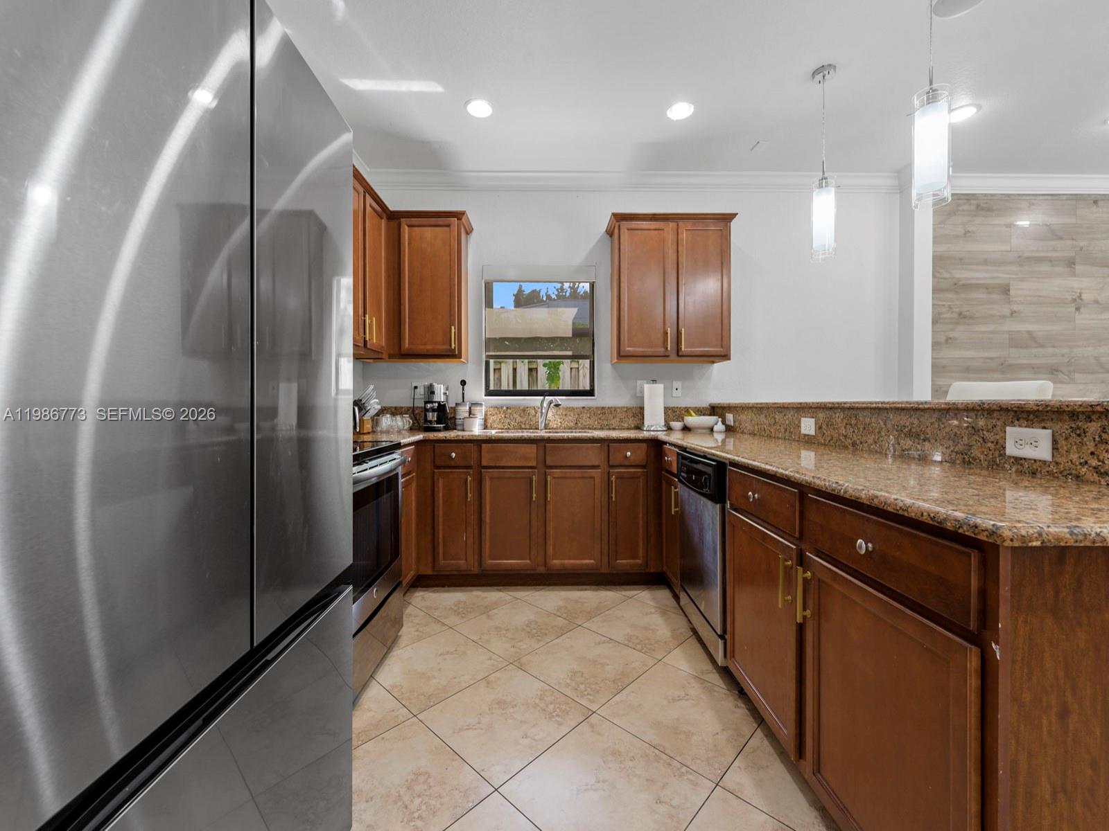 15404 Southwest 175th Street Miami, FL 33187 - Photo 10 of 38 a kitchen with stainless steel appliances granite countertop a sink counter space cabinets and a large window