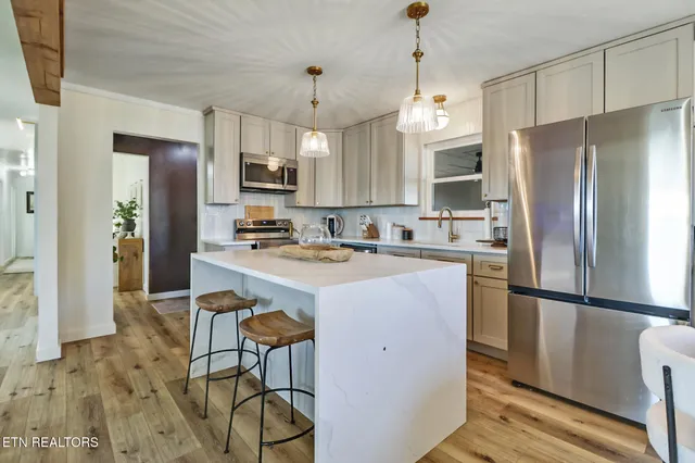 a kitchen with kitchen island a counter top space appliances and cabinets