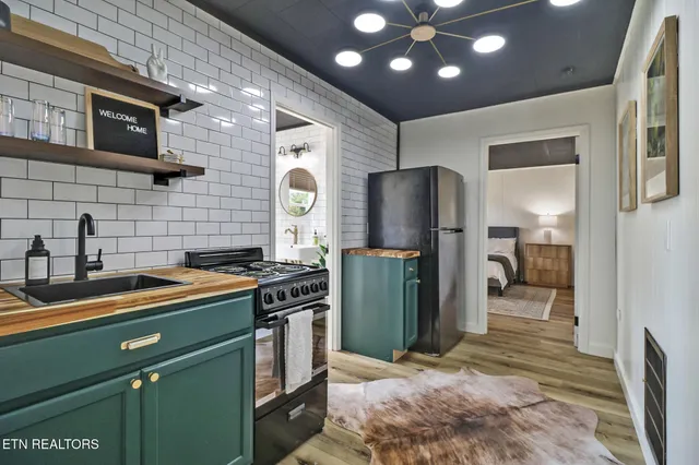 a kitchen with stainless steel appliances granite countertop a refrigerator a stove and a sink