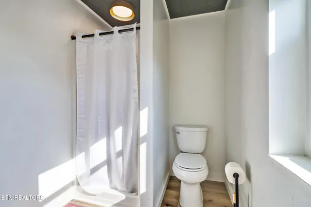 a bathroom with a toilet and a shower