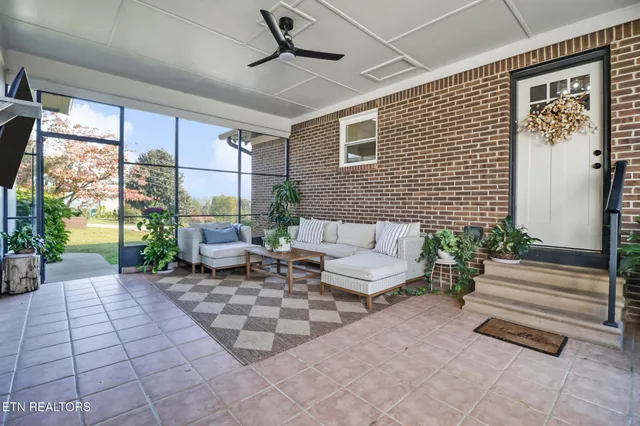 a living room with patio furniture and a floor to ceiling window