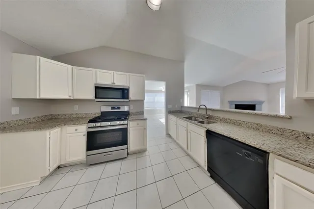 a kitchen with stainless steel appliances granite countertop a sink and a stove