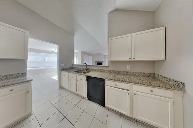 a kitchen with white cabinets appliances and a sink