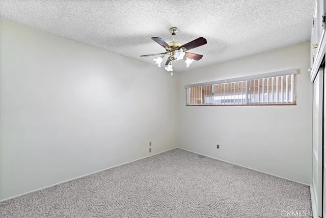 a view of an empty room with a ceiling fan