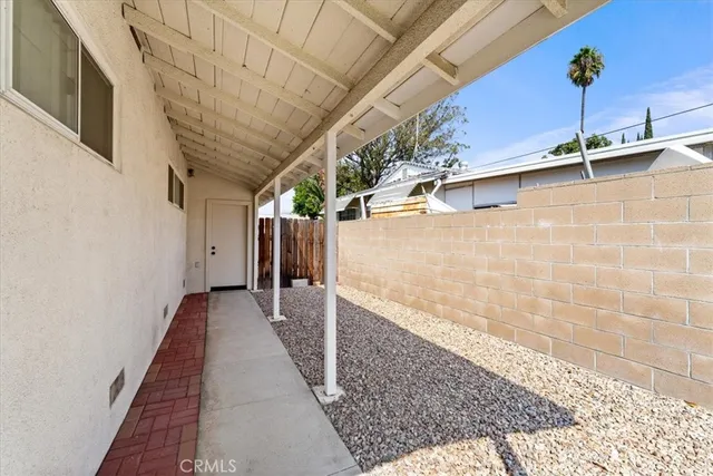 a view of a patio with a table and chairs and potted plants