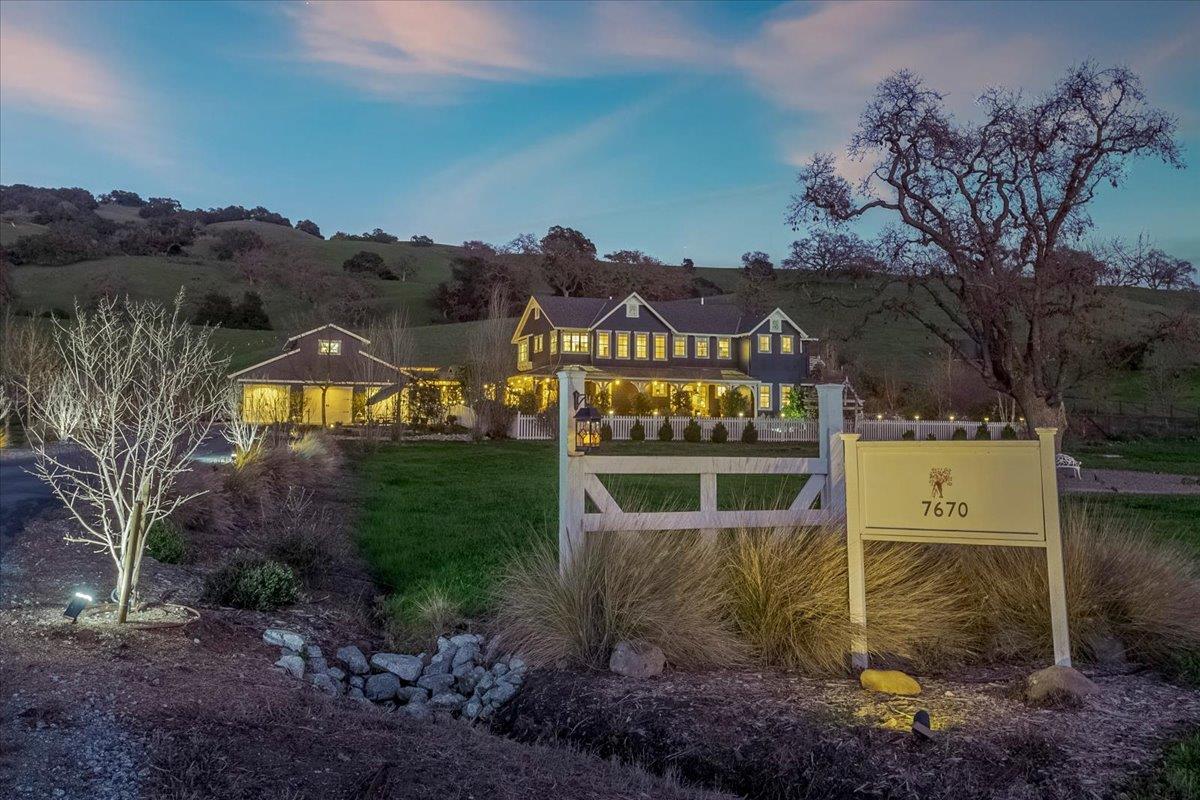 a view of a house with a yard and a tree