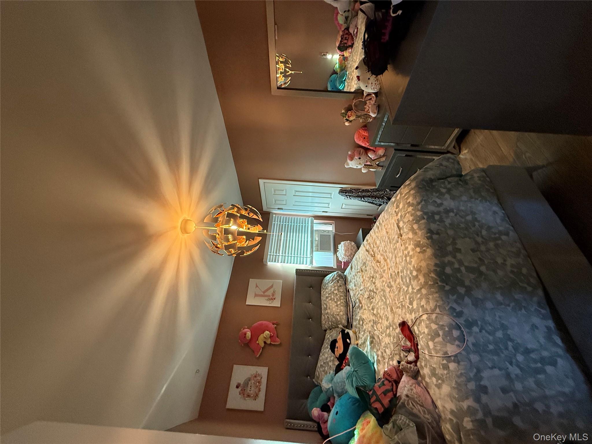 17 Hampton Road Shirley, NY 11967 - Photo 13 of 26 a bedroom with a bed and a chandelier