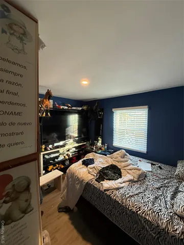 a bedroom with a bed and a television