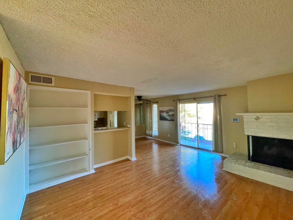 2800 Jeanetta Street, Unit 1110 Houston, TX 77063 - Photo 3 of 6 a view of empty room with wooden floor and fireplace