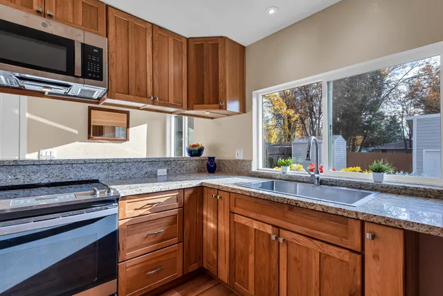 a kitchen with stainless steel appliances wooden cabinets a sink and a microwave