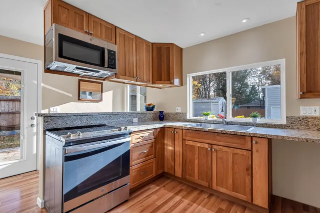 a kitchen with stainless steel appliances a stove sink microwave and refrigerator