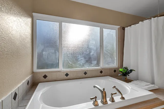 a bath tub sitting in a bathroom next to a window