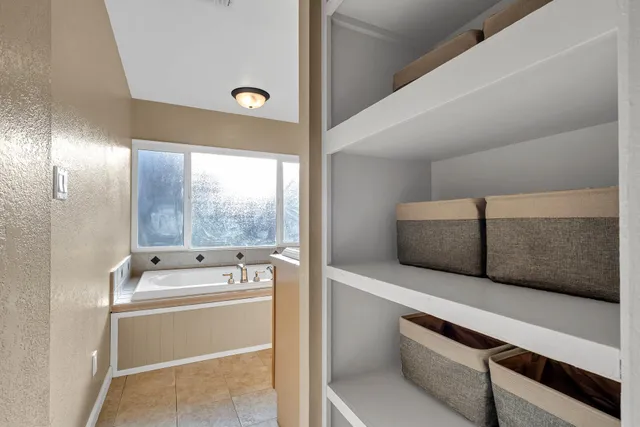 a bathroom with a tub sink and mirror