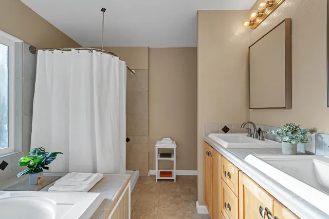 a bathroom with a granite countertop sink a large mirror and a shower