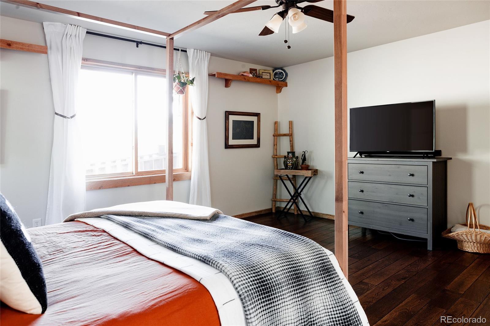 13574 Baird Road Conifer, CO 80433 - Photo 13 of 50 a bedroom with a bed and a flat screen tv