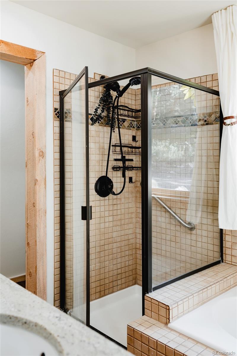 13574 Baird Road Conifer, CO 80433 - Photo 16 of 50 a bathroom with a glass shower door