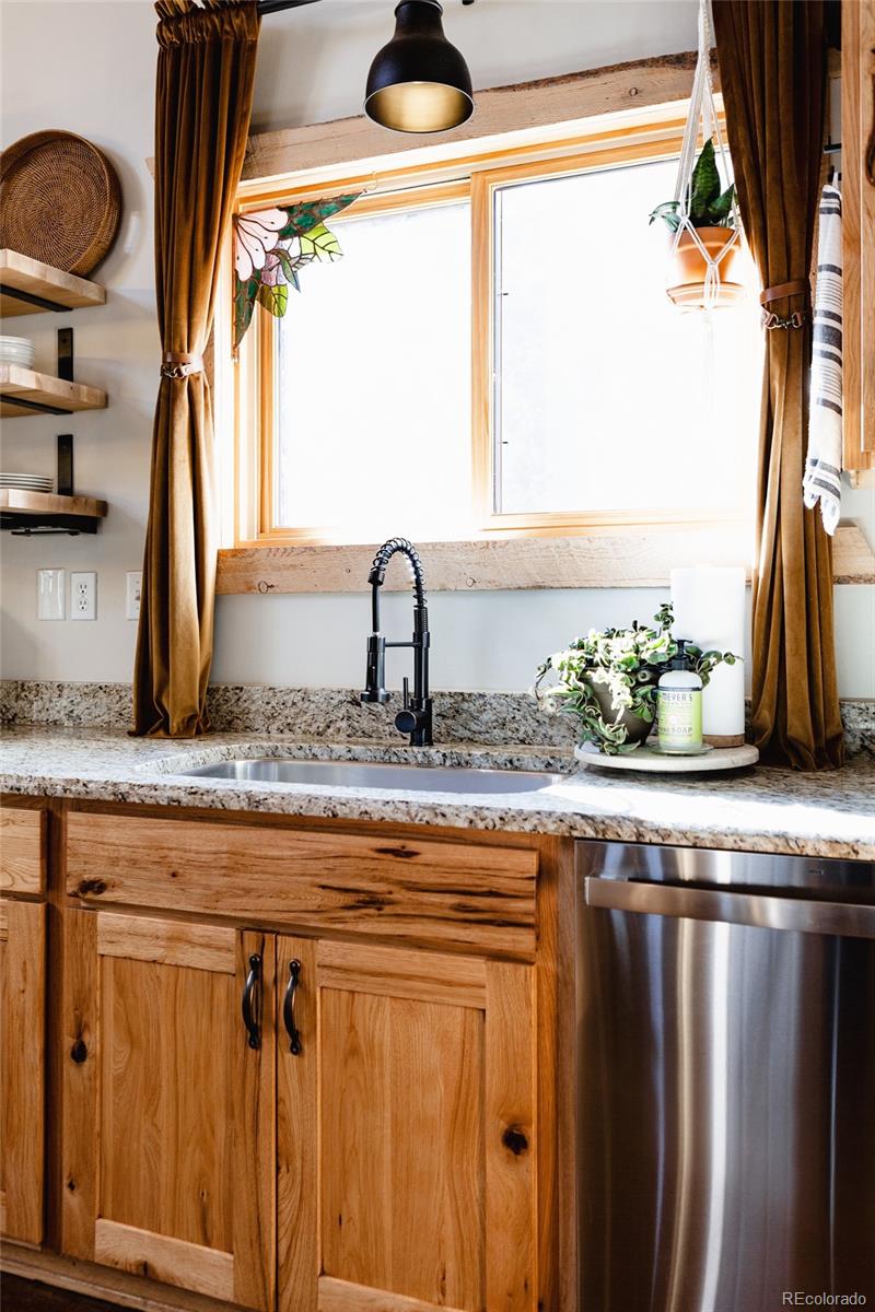 13574 Baird Road Conifer, CO 80433 - Photo 8 of 50 a kitchen with granite countertop a sink a window and stainless steel appliances