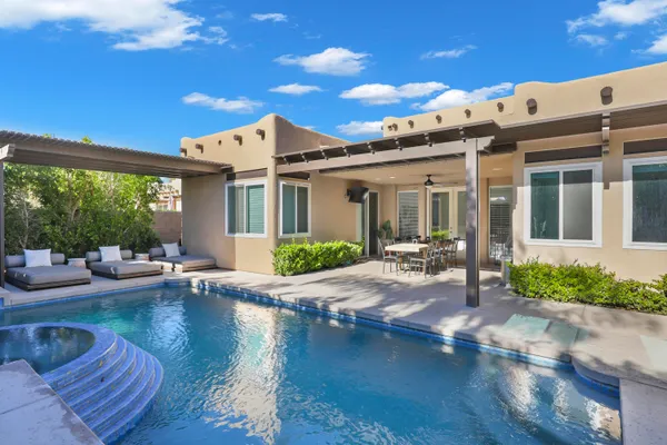 a view of a house with pool and sitting area