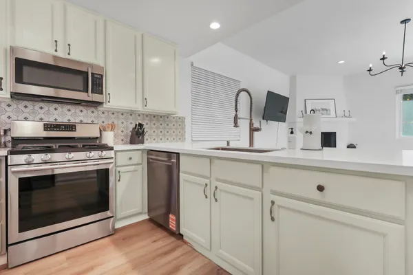 a kitchen with white cabinets stainless steel appliances and sink