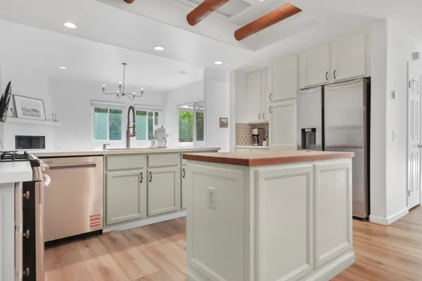 a kitchen with white cabinets and refrigerator