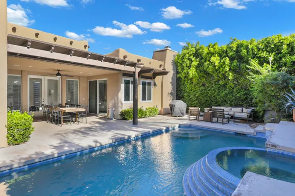 a view of a house with pool and sitting area
