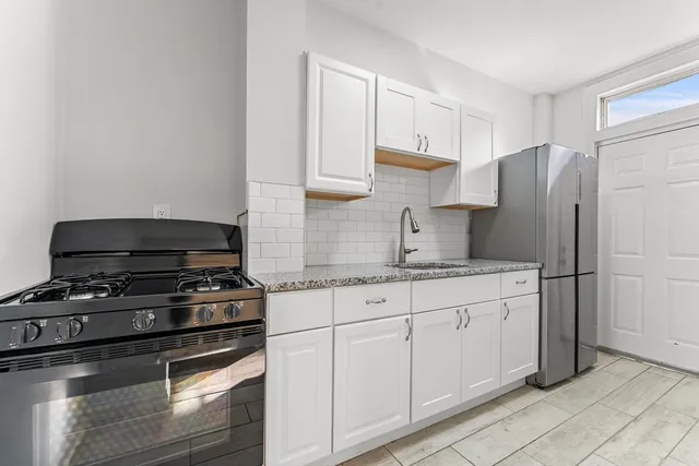 a kitchen with stainless steel appliances granite countertop a stove a refrigerator and a sink