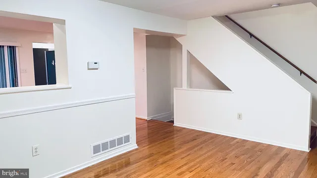 a view of a hallway with wooden floor and entryway