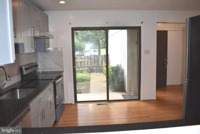 a kitchen with granite countertop a sink and a refrigerator