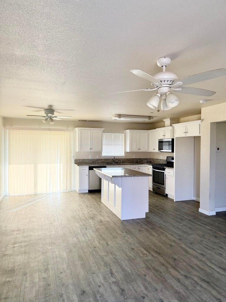 1310 North Belmont Road Exeter, CA 93221 - Photo 3 of 15 a kitchen with stainless steel appliances a large counter top a stove and a refrigerator