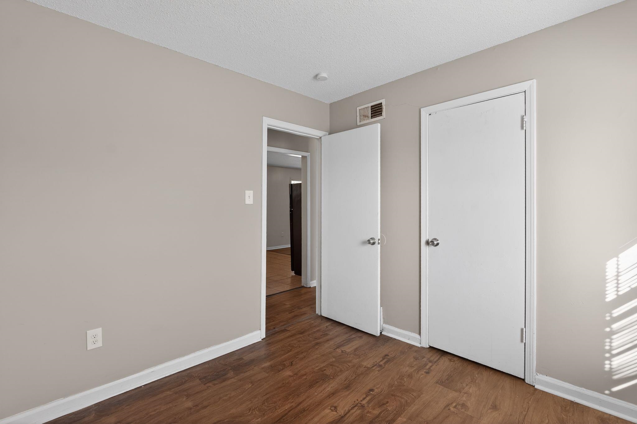 3637 Neely Road Memphis, TN 38109 - Photo 19 of 30 Unfurnished bedroom featuring dark wood-style flooring and a textured ceiling