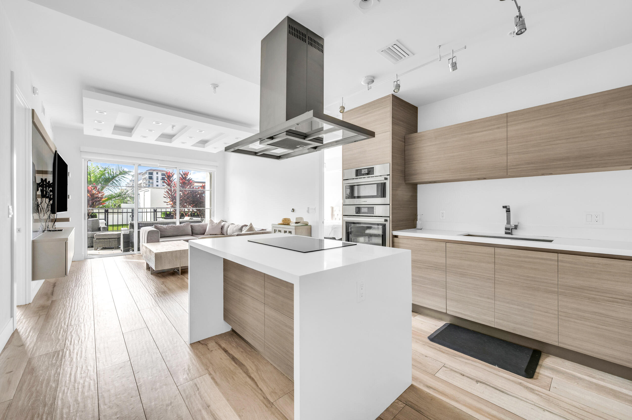 a kitchen with stainless steel appliances a stove a sink dishwasher and white cabinets with wooden floor