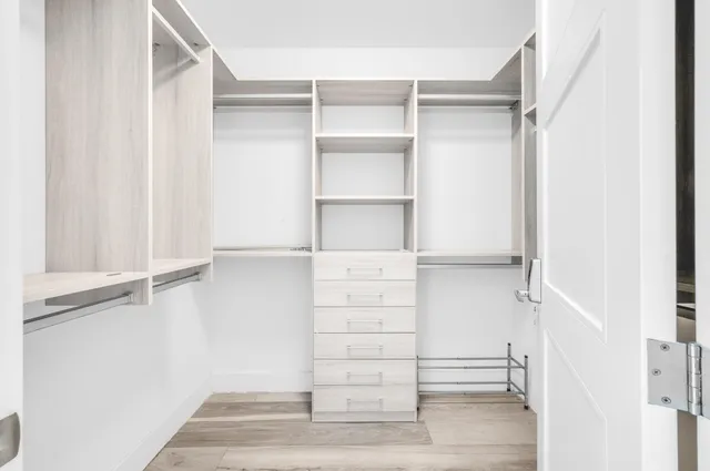 a view of walk in closet with empty racks