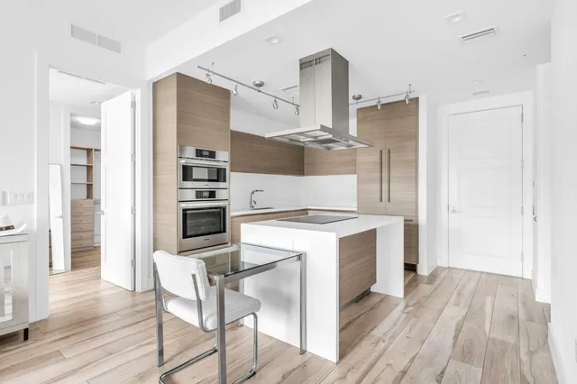 a kitchen with a stove a refrigerator and wooden floor
