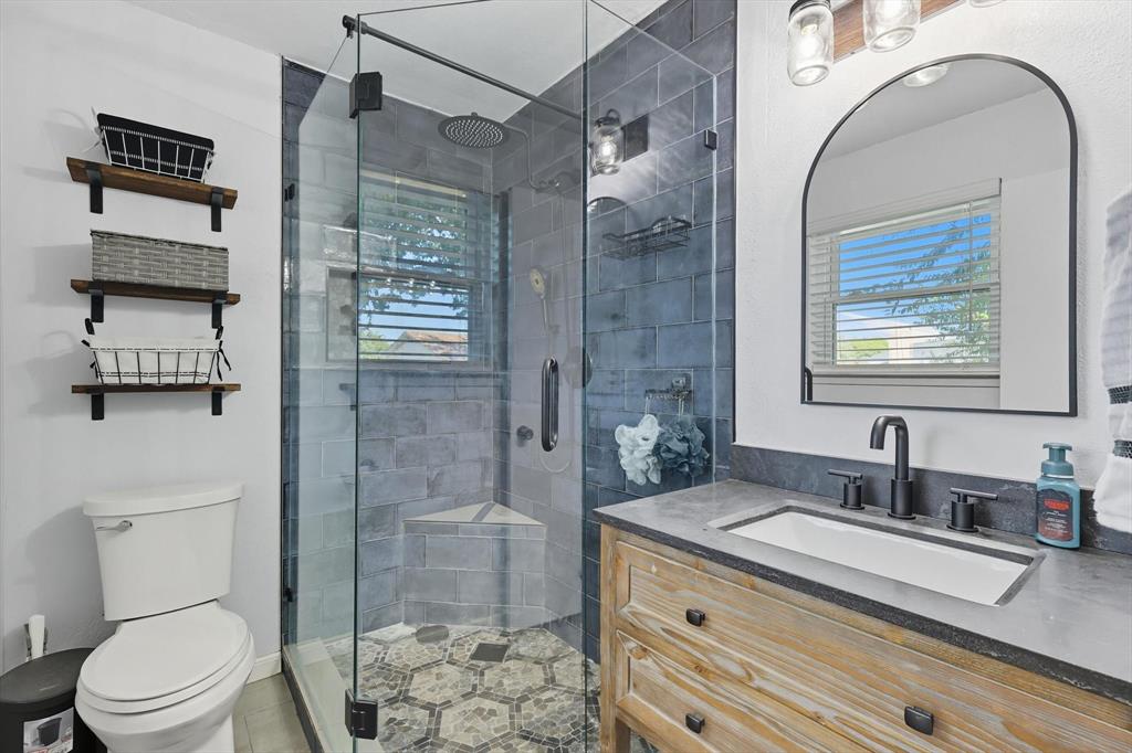 a bathroom with a sink a toilet and shower