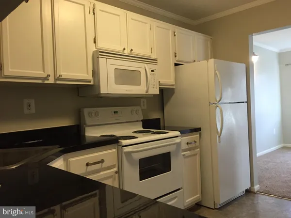 a kitchen with stainless steel appliances white cabinets and a refrigerator
