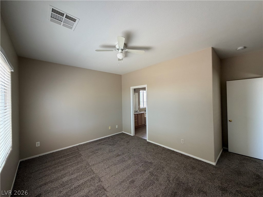 10975 Pumpkin Ridge Avenue Las Vegas, NV 89135 - Photo 5 of 13 A comfortable bedroom features plush carpeting and a convenient en-suite bathroom access.