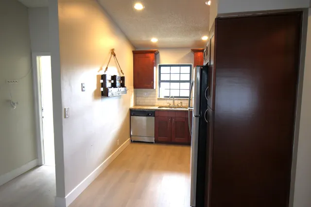 a view of hallway with cabinets and a bathroom