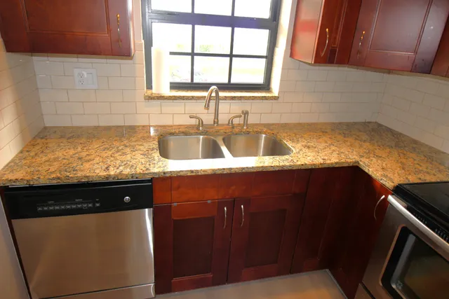 a kitchen with granite countertop cabinets sink and window