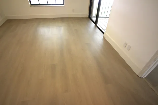 a view of a room with wooden floor and a window