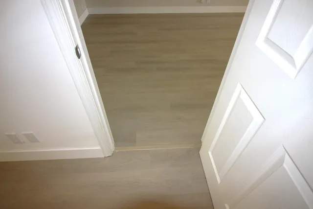 a view of staircase with white walls and white door