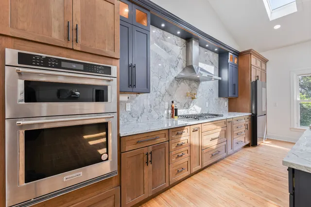 a kitchen with stainless steel appliances granite countertop white cabinets a sink and dishwasher
