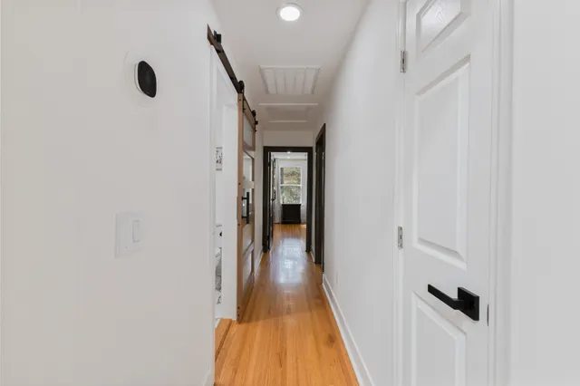 a view of a hallway with wooden floor and staircase
