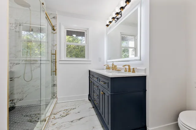 a bathroom with a sink a toilet and shower